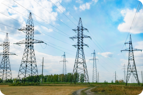 Rows of powerlines are shown with a partly cloudy blue sky.